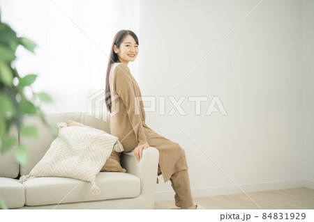 ソファのヘリに座る女性（同棲） 84831929