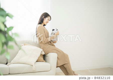 部屋で赤ちゃんを抱く女性 84832110