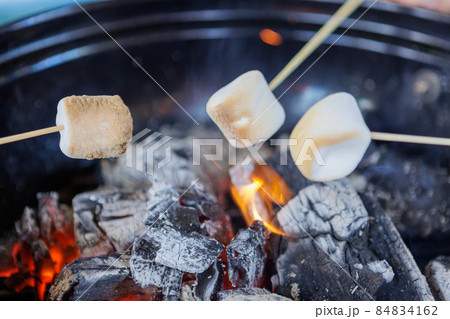 キャンプで焚き火と焼きマシュマロ キャンプで焚き火と焼きマシュマロ 84834162