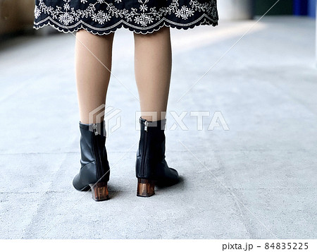絨毯フロアの上に立つ女性のブーツの足元 84835225