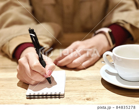 カフェでメモを取る女性の手元 カフェでメモを取る女性の手元 84835278