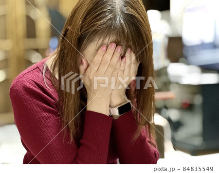 部屋で顔を覆って泣く女性 84835549