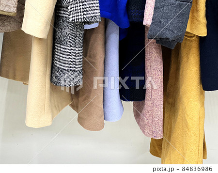クローゼットの中に並んだコート類のすそ 84836986