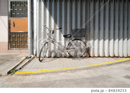 Horizontal traditional retro Hong Kong style silver shop rolling door with old vintage bicycle 84839255