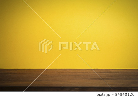 Empty clean yellow backagrund with wooden table. Copy space 84840126