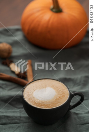 Pumpkin spicy latte in black cup on linne cloth Pumpkin spicy latte in black cup on linne cloth 84842452