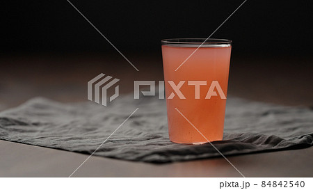 guava drink from can into tumbler glass on table 84842540