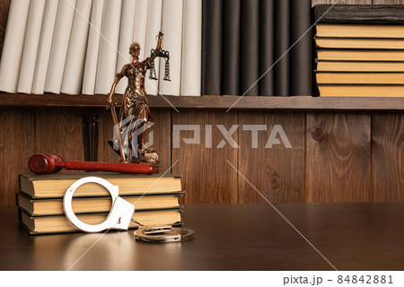 Lady Justice, Judge's gavel, books, handcuffs on an old wooden table Lady Justice, Judge's gavel, books, handcuffs on an old wooden table 84842881