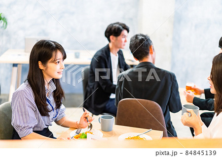明るい雰囲気の社員食堂でランチを取るオフィスワーカー 84845139