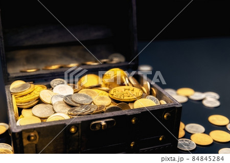 Heap of coins in small wooden chest 84845284