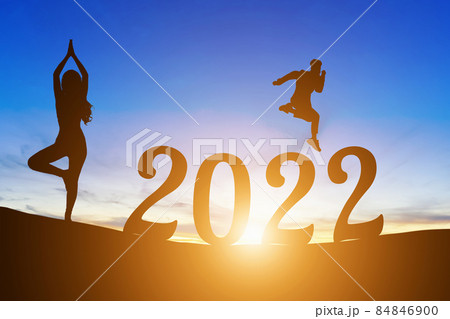 Happy New Year Numbers 2022, Silhouette a man handsome jumping feels happy moving  and woman practicing yoga early morning sunrise over the horizon background, Health and Happy new year concept. 84846900