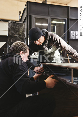 Two joiners check the quality of work at workstation 84850761