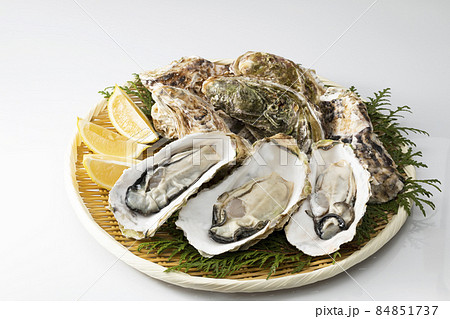 白バックでざるに乗せたむき身で殻付きの牡蠣 84851737