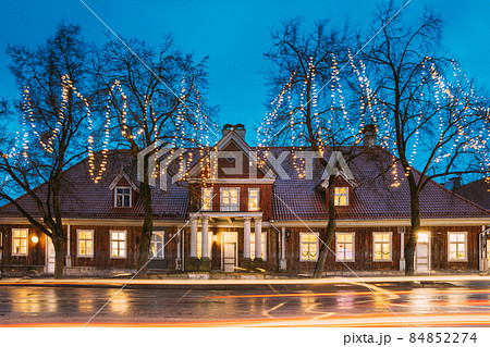 Kuressaare, Estonia. Old Wooden House In Tallinna Street At Evening Night. Street In Fesive Christmas Xmas New Year Illuminations. Kuressaare, Estonia. Old Wooden House In Tallinna Street At Evening Night. Street In Fesive Christmas Xmas New Year Illuminations. 84852274
