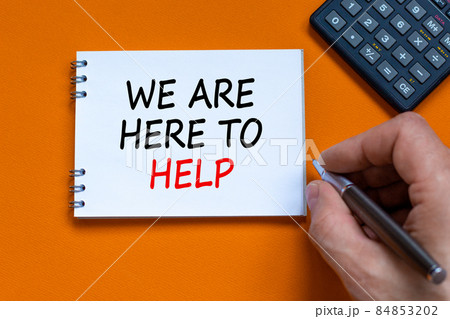 Support symbol. Businessman writing words 'we are here to help' on white note. Black calculator. Beautiful orange background. Copy space. Business and support concept. 84853202