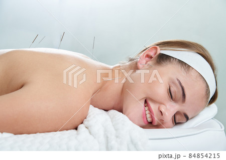 Doctor puts needles into female back on the acupuncture treatment therapy in spa salon. Alternative Medicine concept Doctor puts needles into female back on the acupuncture treatment therapy in spa salon. Alternative Medicine concept 84854215