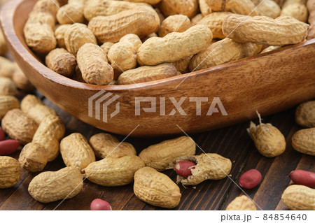 Raw organic peanuts in a wooden bowl. 84854640
