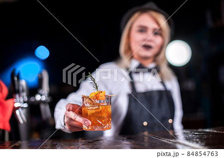 Charming woman mixologist makes a cocktail Charming woman mixologist makes a cocktail 84854763