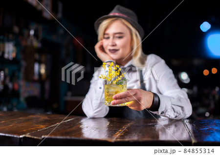 Confident girl bartending decorates colorful concoction in the night club 84855314