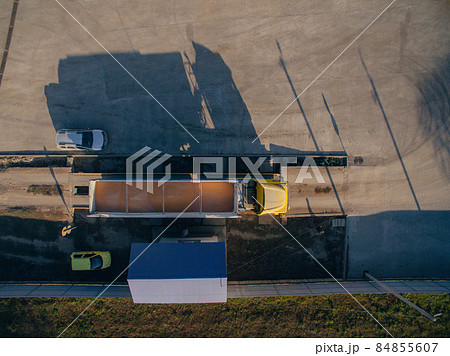 Aerial View Over The Truck. Unloading of Corn Grain in the Warehouse. 84855607