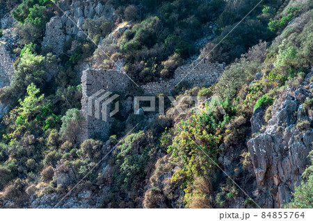 ruins of fortress walls on rocky mountain slopes near the ancient city of Olympus, Turkey 84855764