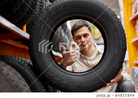 male customer taking new tires in the supermarket. 84855844
