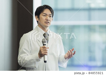 マイクを持って話す白衣の男性 医師 研究者 84855921