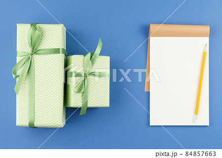 Presents in colored paper with an open notebook. 84857663