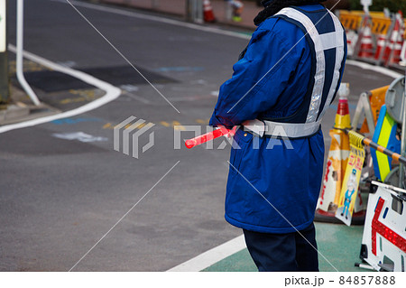 赤く光るLED誘導棒を持った交通誘導員 84857888