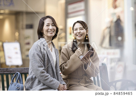 コートを着てスマホを見る2人の女性 84859465