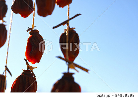 軒下につるされた干し柿 84859598