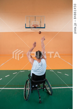 a photo of a person with a disability playing basketball in a modern sports arena. The concept of sport for person with a disability. Selective focus  84861450
