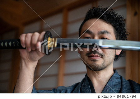 刀を見つめる日本人のサムライか刀の鑑定する人 84861794