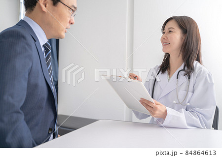 問診表で診察する女医と男性患者メディカルイメージ 84864613