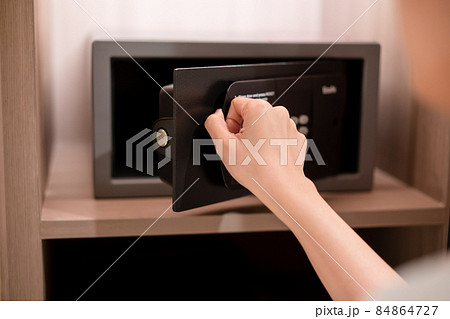 Businesswoman opening safe box door. 84864727