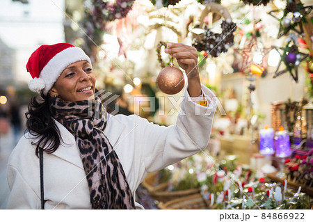 Woman choosing christmas decorations at fair 84866922