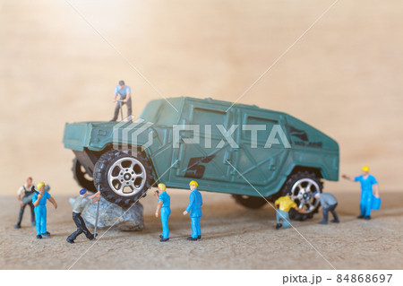 Miniature people mechanics fix A military vehicle 84868697