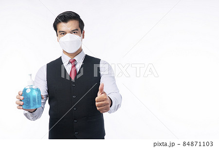 Confident positive handsome businessman holding alcohol gel bottles own hand while showing thumb up Confident positive handsome businessman holding alcohol gel bottles own hand while showing thumb up 84871103