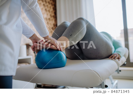 Close up hands of physiotherapist woman exercising with unrecognizable overweight woman indoors in rehabilitation center 84871345