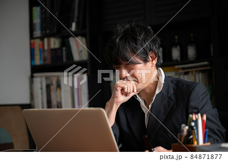 パソコンを見ながら考えるハンサムなアジア人（日本人）ビジネスマン男性　左にコピースペース 84871877