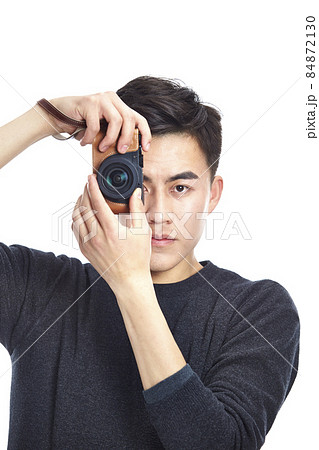 young asian man taking a picture with camera, isolated on white background young asian man taking a picture with camera, isolated on white background 84872130