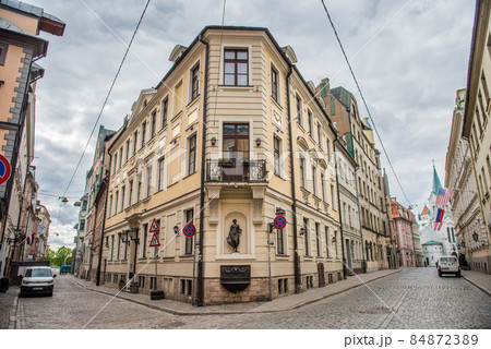 Riga, Latvia - Building on the corner of Pils and Miesnieku streets. Statue of woman with amphora 84872389