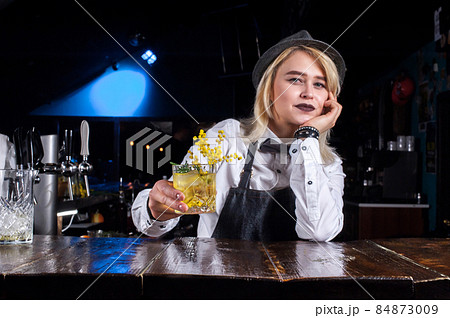 Focused girl bartending demonstrates his professional skills in cocktail bars 84873009