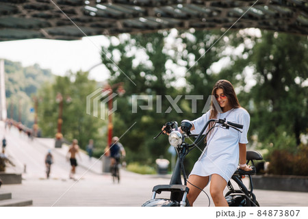 Young beautiful woman and an electric scooter, ecological transport 84873807