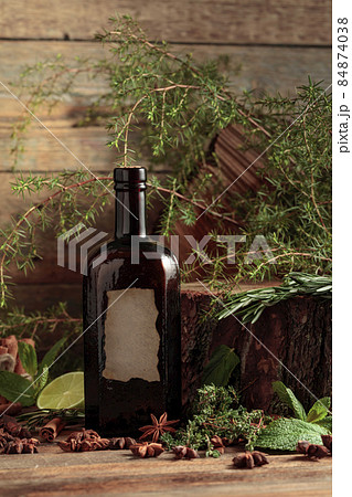 Vintage bottle of gin and various ingredients on an old wooden table. 84874038