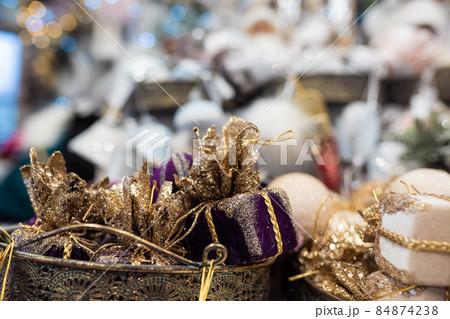 Different object toy gifts hanging from a decorated Christmas tree. 84874238