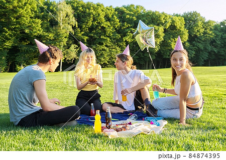 Teenage birthday party picnic on the grass in the park Teenage birthday party picnic on the grass in the park 84874395