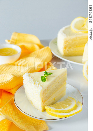 Lemon cake with coconut flakes. A piece of delicate vanilla dessert with cream. Lemon cake with coconut flakes. A piece of delicate vanilla dessert with cream. 84876865