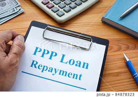 A man holds PPP loan repayment application. 84878323