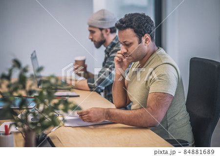 Two guys with laptop and smartphone working in office Two guys with laptop and smartphone working in office 84881689